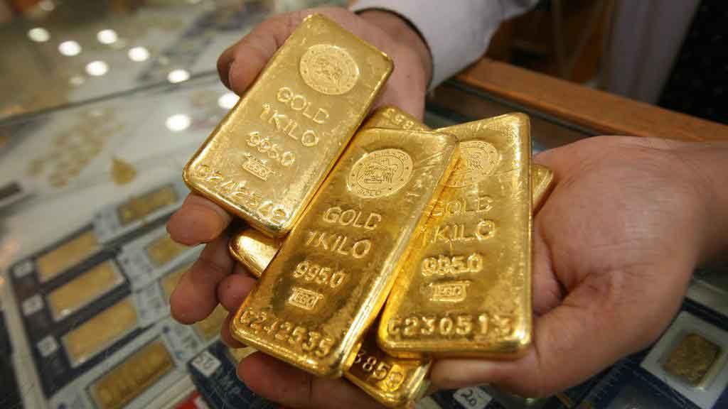 Refined gold bars displayed by hand